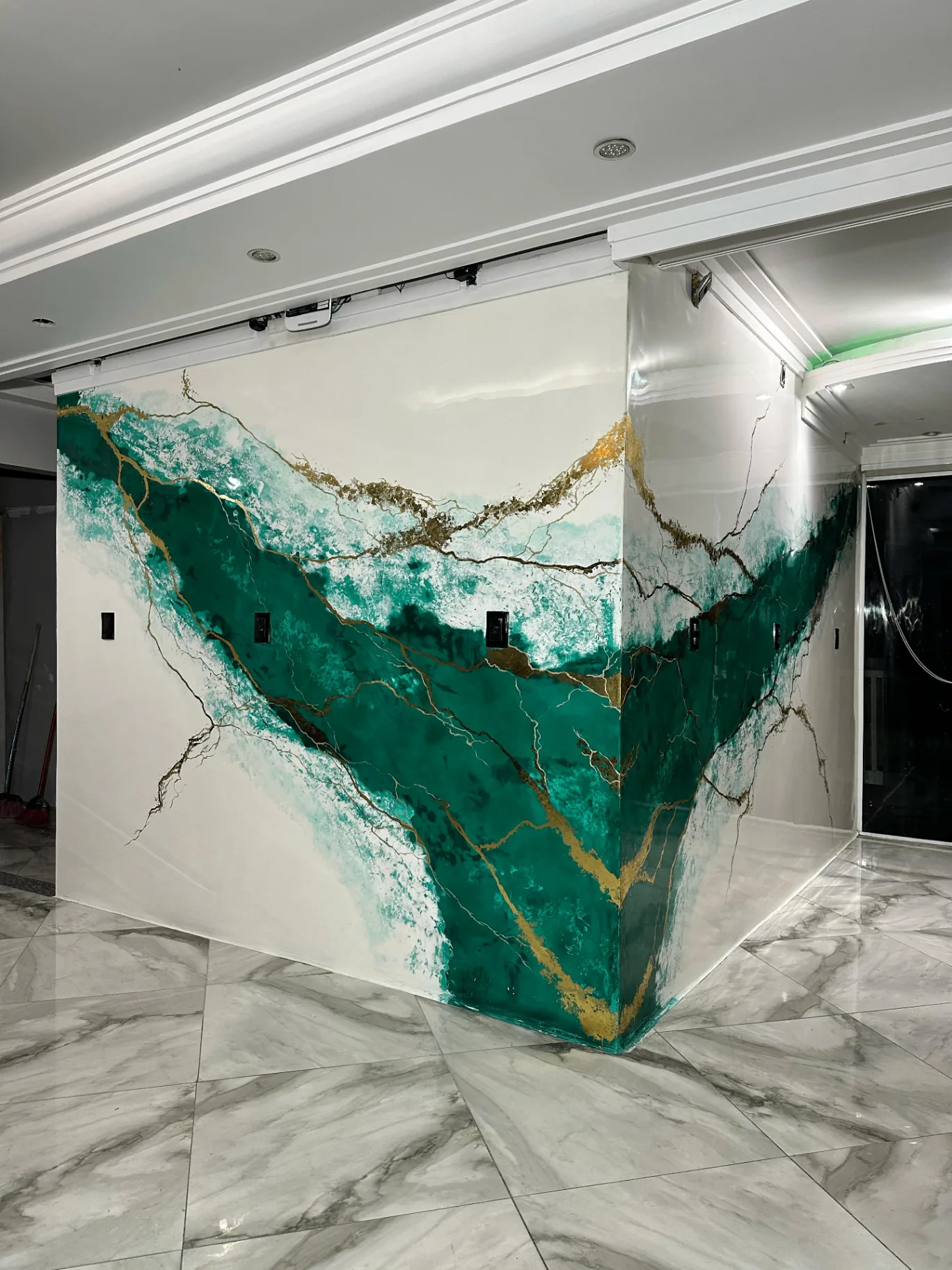 Emerald green Venetian plaster wall with gold veining — signature installation
